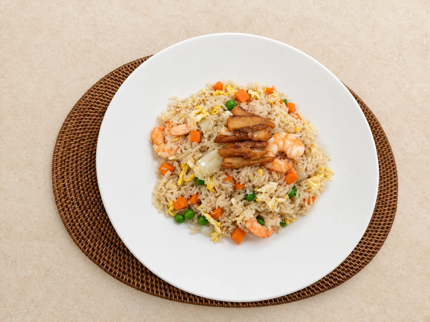 Fried rice with vegetables served on a round white plate